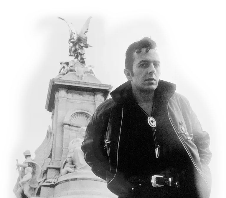 Black and white portrait photograph of Joe Strummer outside Buckingham Palace, London, by Josh Cheuse